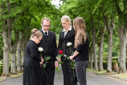 family holding flowers cemetery