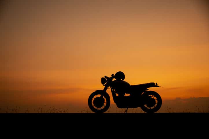 A silhouette of a motorcycle in front of the horizon.