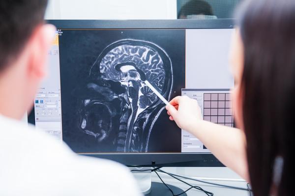 doctor reviewing medical imagery with a brain injury patient