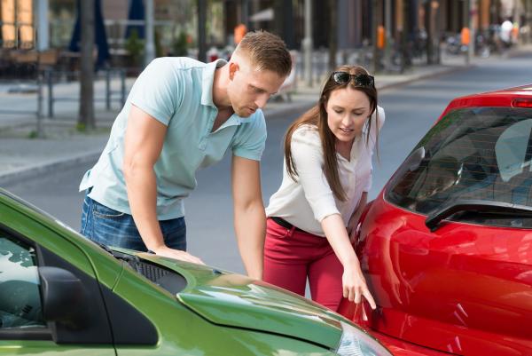 2 people assessing the damage to their vehicles after a car accident