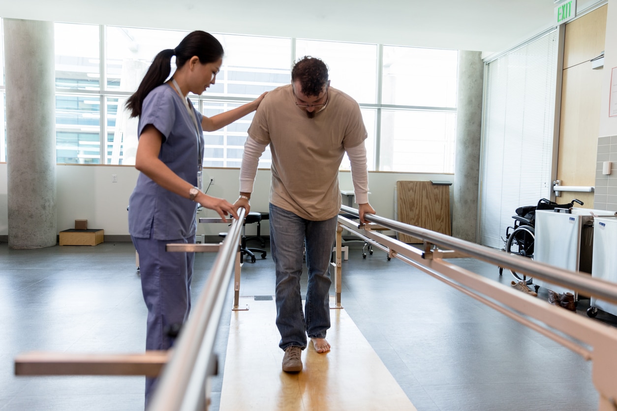 A rehabilitation specialist assists an injured man with an exercise