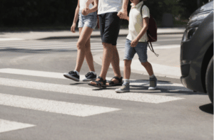 Children crossing the street with their father