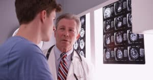 A doctor reviewing brain scans with a brain injury patient