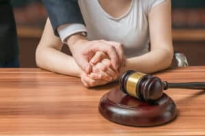 A lawyer’s hand on top of a client’s hands during a social security disability hearing