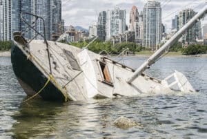 A sailboat sinking in the water after a boating accident.