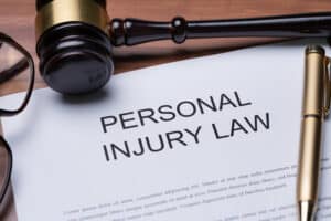 A gavel and pen on a piece of paper with the words “personal injury law” written on it