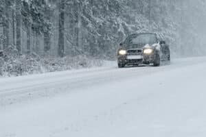 Car driving on roads in snowy winter conditions