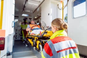 Injured construction worker being loaded into an ambulance by emergency responders