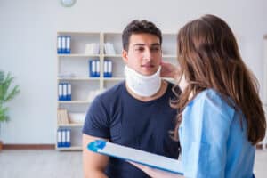 Young man with neck brace talking with a doctor