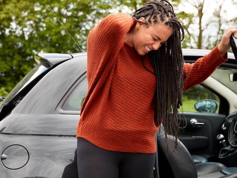 Woman suffering from an exacerbated existing back injury after a care accident.