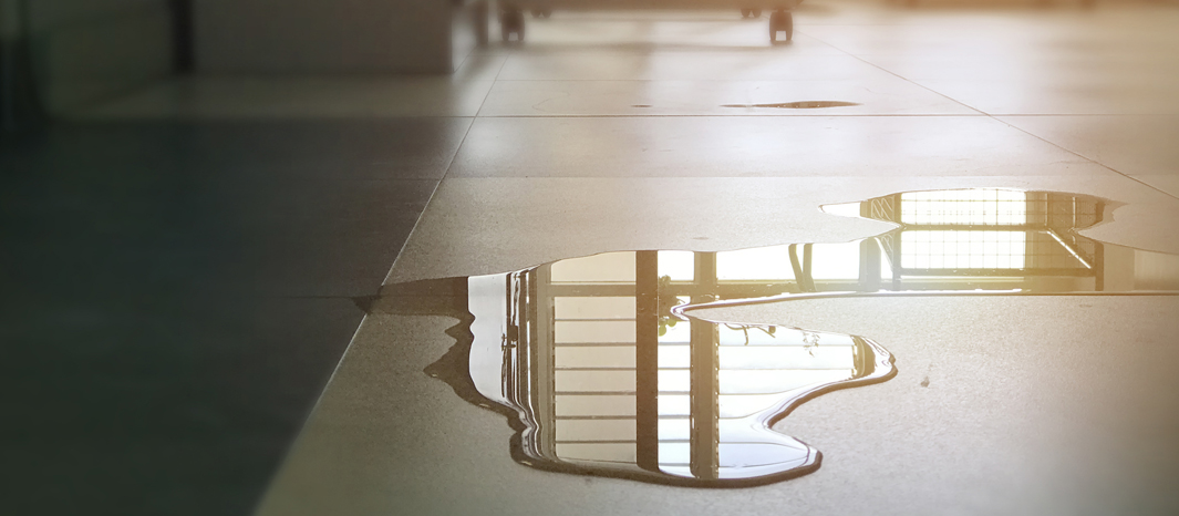 Large puddle of water on the floor with no caution sign, a hazard that could cause an injury.