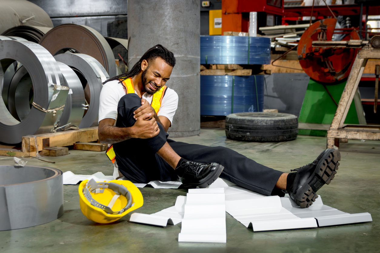Policeman going over car accident scene Injured factory worker holding his knee after a workplace accident.